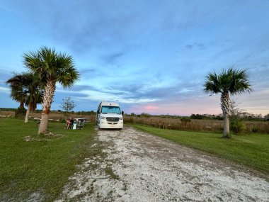 Everglades, FL USA - 5 Aralık 2023: Florida, ABD 'deki Everglades Ulusal Parkı' ndaki güzel bir gün batımında bir kamp yerine park edilmiş bir minibüs..