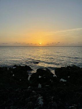 A view of the ocean in Grand Cayman Island with a beautiful summer sunset in West Bay. clipart