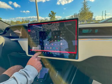 Orlando, FL USA - 9 Aralık 2024: Test sürüşü için S modelini kuran bir kişi ile bir Tesla üzerinde bilgi ekranı.