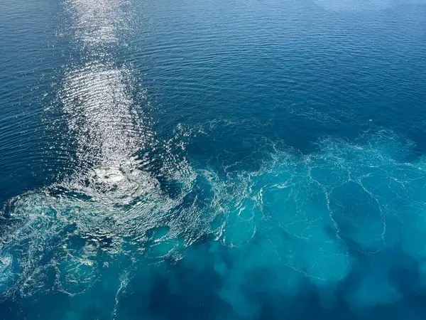 Gemi seyahati güzel güneşli bir günde beyaz bulutlar ve çalkantılı mavi denizlerle Atlantik Okyanusu 'nda uyanır..