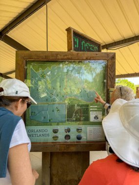 Orlando, FL USA - 14 Nisan 2025 Orlando, Florida yakınlarındaki Orlando Wetlands vahşi yaşam parkının girişindeki ziyaretçi merkezinde bir rehber.