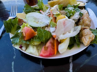 Güneşli bir günde bir yolcu gemisinde, açık bir restoranda mermer bir masada salata..