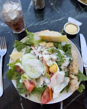 Güneşli bir günde bir yolcu gemisinde, açık bir restoranda mermer bir masada salata..