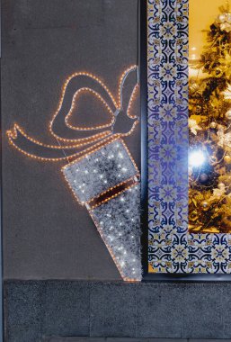 Binanın duvarını parlak dekoratif lambalarla süsledim. Noel, Yeni Yıl.