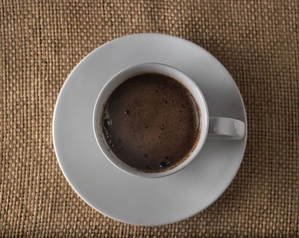 テーブルクロス トップビューの背景に白いカップで芳香のあるコーヒー — ストック写真