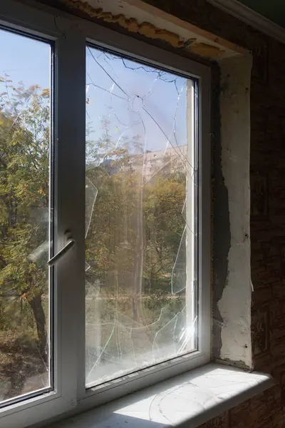 Window of a house after a rocket attack. Broken glass windows, broken window from an explosion.