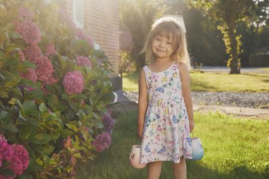 Kelebek gibi giyinmiş sevimli çocuk çiçeklerden polen topluyor..