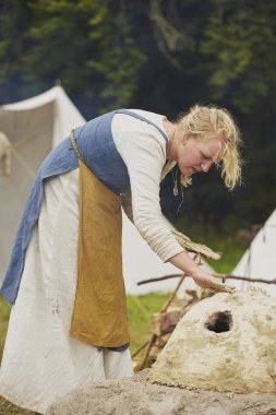 Hojbjerg, Danimarka, 29 Temmuz 2023: Kadın Viking festivalinde kil fırın yapıyor