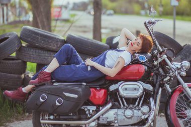 Yol kenarındaki bir atölyede motosikletli güzel bir tamirci kız..