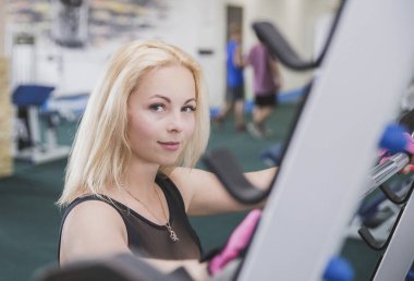 Çekici sarışın jimnastik salonunda çömelmiş duruyor..