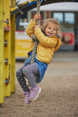 Çekici çocuk Danimarka 'da bir oyun parkında ipe tırmanıyor..