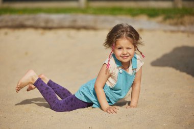 Danimarka 'da yaz mevsiminde kum havuzunda oynayan sevimli bir çocuk..
