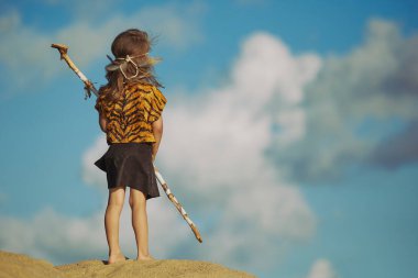 Cute baby dressed in the clothes of primitive people.