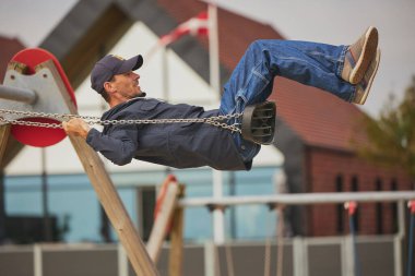 Ringkobing, Danimarka, 2 Temmuz 2024: Salıncakta sallanan adam.
