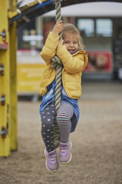 Çekici çocuk Danimarka 'da bir oyun parkında ipe tırmanıyor..
