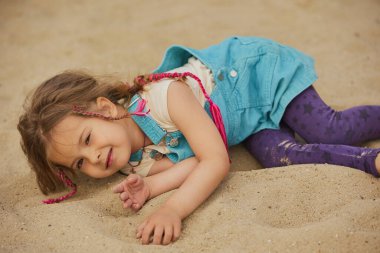 Danimarka 'da yaz mevsiminde kum havuzunda oynayan sevimli bir çocuk..