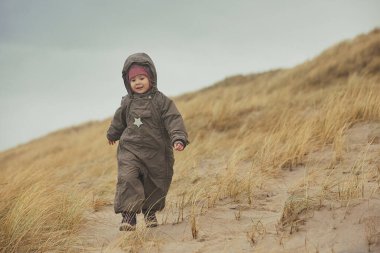 Adorable child playing in the grass in Denmark. clipart