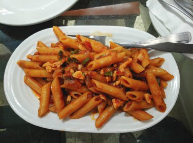 Domates soslu makarna, koyu arkaplanda parmesan peyniri ve fesleğen. Kopyalama alanı olan üst görünüm.