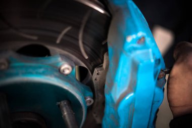 Araba tamircisi ya da tamirci araba tamirhanesinde ya da tamirhanede tamir ve onarım sorunları için disk freni ve asbest fren pedlerini kontrol ediyor.