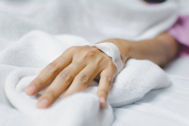 Hasta 40 'lı yaşlarda C-line' da salin damar yolu ya da yoğun bakım ünitesinde hasta yatağında hasta eli üzerinde A-hattı (Yoğun bakım ünitesi). Hastanedeki oda.