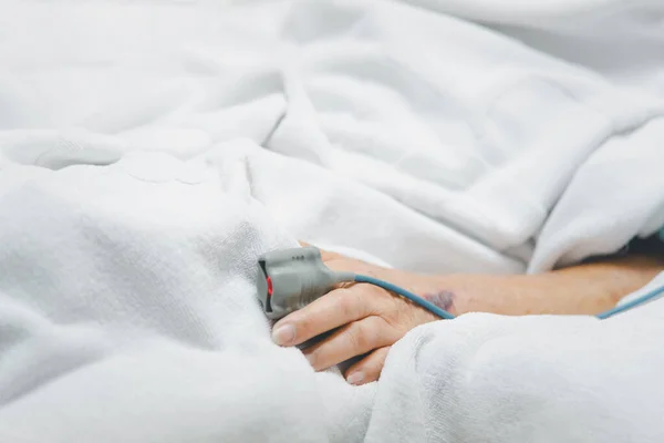 80歳以上のアジア系高齢女性80歳以上のインフルエンザは 集中治療室 Icu の患者のベッドで高齢者の指の心拍測定と血圧のためのパルスゲージで19をカバーしています 病院の部屋で — ストック写真