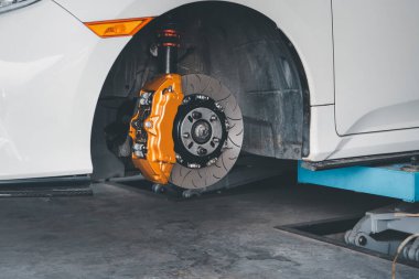 Araba tamircisi ya da tamirci araba tamirhanesinde ya da tamirhanede tamir ve onarım sorunları için disk freni ve asbest fren pedlerini kontrol ediyor.