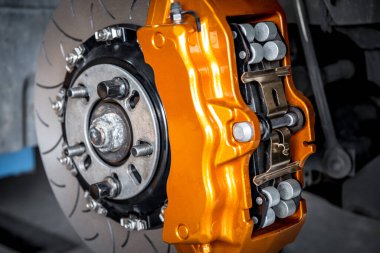 Araba tamircisi ya da tamirci araba tamirhanesinde ya da tamirhanede tamir ve onarım sorunları için disk freni ve asbest fren pedlerini kontrol ediyor.