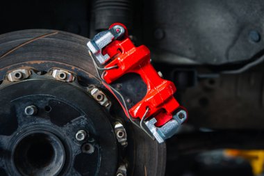 Araba tamircisi ya da tamirci araba tamirhanesinde ya da tamirhanede tamir ve onarım sorunları için disk freni ve asbest fren pedlerini kontrol ediyor.