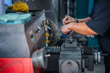 Araba tamircisi ya da tamirci araba tamirhanesinde ya da tamirhanede tamir ve onarım sorunları için disk freni ve asbest fren pedlerini kontrol ediyor.