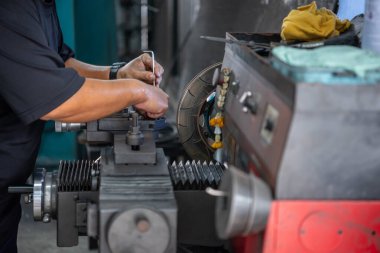 Araba tamircisi ya da tamirci araba tamirhanesinde ya da tamirhanede tamir ve onarım sorunları için disk freni ve asbest fren pedlerini kontrol ediyor.