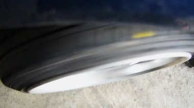 Araba tamircisi ya da tamirci tekerlek hizalaması ve lastik dengesi araba tekerini tamir ve tamir sorunu için kontrol ediyor.