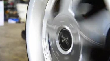 Araba tamircisi ya da tamirci tekerlek hizalaması ve lastik dengesi araba tekerini tamir ve tamir sorunu için kontrol ediyor.