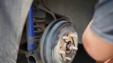 Araba tamircisi ya da tamirci araba tamirhanesinde ya da tamirhanede tamir ve onarım sorunları için disk freni ve asbest fren pedlerini kontrol ediyor.