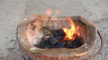 Asyalı aşçı Tayland mutfağında geleneksel taşra tarzında yemek pişiriyor, eski kömür ocağını alevlerle yakıyor ve Tayland yemeği pişirmek için otantik dumanlar tütüyor.