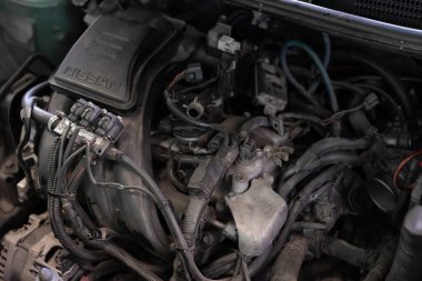 Bangkok, Tayland - 4 Mayıs 2023: Tanımlanamayan araba tamircisi, araba motorunun yağını değiştirdiği için araba garajındaki eski kayganlaştırıcı motor yağını boşalttı