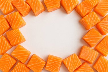 Yapay zeka taze çiğ somon balığının üst görüntüsünü oluşturdu. Kalın kaliteli filetolar halinde kesilmiş. Canlı turuncu-pembe renkler sergiliyor ve temiz beyaz arka planda parlayan mermerler sergiliyordu.