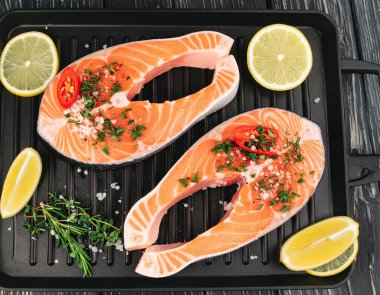 Yapay zeka kömürün üzerinde ızgara yapılmış, çıtır çıtır deri ve hafif dumanla mükemmel pişirilmiş lezzetli somon bifteği parçaları üretti. Tuz ve karabiberle tatlandırılmış, taze biberiyeyle süslenmiş..