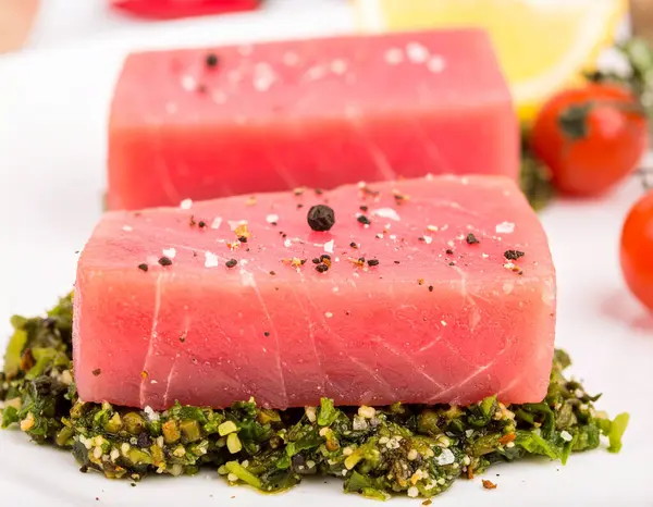 Yapay zeka kömürün üzerinde ızgara yapılmış hafif dumanla mükemmel kurutulmuş ton balıklı bifteğin en üst görüntüsünü oluşturdu. Tuz ve karabiber ile tatlandırılmış, taze biberiye ve limon dilimleriyle süslenmiş..