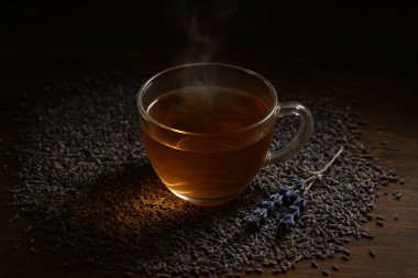 Yapay zeka, ahşap bir masanın üzerinde, yumuşak ve taze lavanta ışıklarıyla çevrili, dumanı tüten bir bardak lavanta çayı görüntüsü oluşturdu.