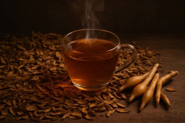 Yapay zeka, sade bir cam fincanda sıcak bitkisel çay üretti. Kaba ahşap masa üzerinde taze ve kurumuş parmak kökleriyle. Keyifsizlik ve doğal tedavi temaları için klasik ışıklandırma altında.