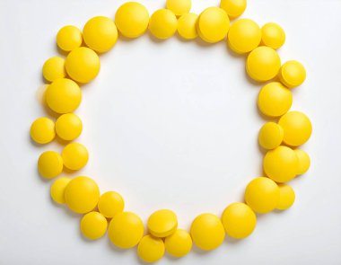 AI, merkezinde el değmemiş beyaz negatif alan bulunan, eczacılık ve sağlık hizmetleri için ideal, parlak sarı tabletlerden oluşan dairesel bir düzenleme içeren profesyonel tıbbi görüntü oluşturdu.