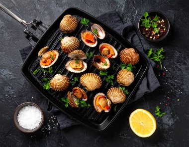 Yapay zeka kömürün üzerinde ızgara yapılmış taze kan midyelerinin üst görüntüsünü oluşturdu. Bazı kabuklar, içindeki sulu eti ortaya çıkardı. Dumanlı aromayla mükemmel pişirilmiş, tuzlu ve karabiberli, süslenmiş.