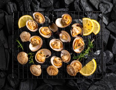 Yapay zeka kömürün üzerinde ızgara yapılmış taze tatlı istiridye manzarası oluşturdu, dumanlı aroma ve sulu etle mükemmel pişirildi. Biberiye ve limon dilimleriyle süslenmiş tuzlu ve karabiberli..