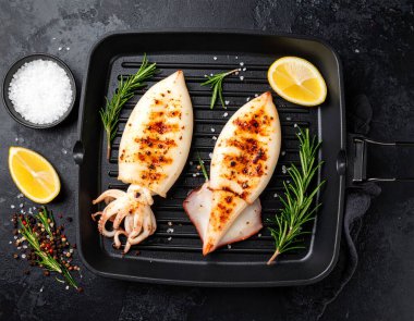 Yapay zeka kömürün üzerinde ızgara yapılmış taze mürekkep balığının üst görüntüsünü oluşturdu. Yumuşak dokular ve aromatik dumanla mükemmel pişirildi. Tuz ve karabiber ile tatlandırılmış, biberiye filizi ile süslenmiş.