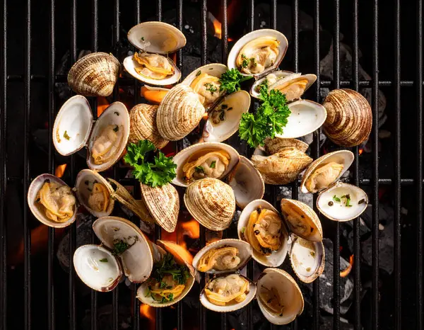 Yapay zeka kömürün üzerinde ızgara yapılmış taze çizgili istiridyelerin üst görüntüsünü oluşturdu, bazı kabuklar içerideki eti ortaya çıkardı. Dumanlı aromayla mükemmel pişirilmiş, tuzlu ve karabiberli, süslenmiş.