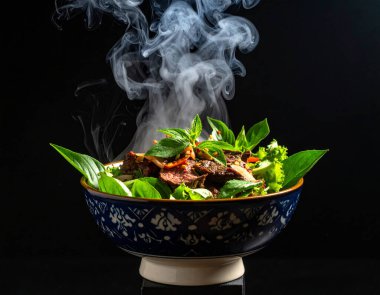 Al, dumanlı Tayland yemeği Sue rong hai ızgara et ve taze malzemelerle süslenmiş Tayland kâsesi sulu salamura edilmiş baharatlı biftek baharatlı soslu aromatik otlar üretti.