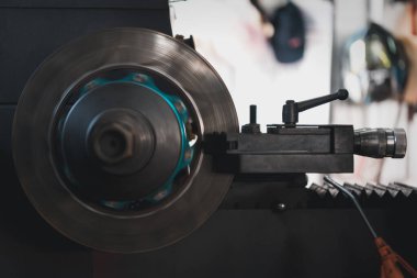 Araba tamircisi ya da tamirci araba tamirhanesinde ya da tamirhanede tamir ve onarım sorunları için disk freni ve asbest fren pedlerini kontrol ediyor.