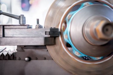 Araba tamircisi ya da tamirci araba tamirhanesinde ya da tamirhanede tamir ve onarım sorunları için disk freni ve asbest fren pedlerini kontrol ediyor.