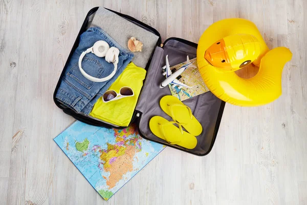 An open suitcase with clothes and leisure accessories. Summer travel, preparation for the trip, packing of luggage.