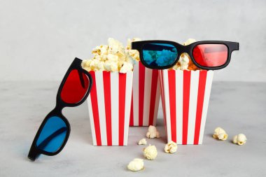 Patlamış mısır, gri arka planda sinema saati için 3D gözlükler.. 